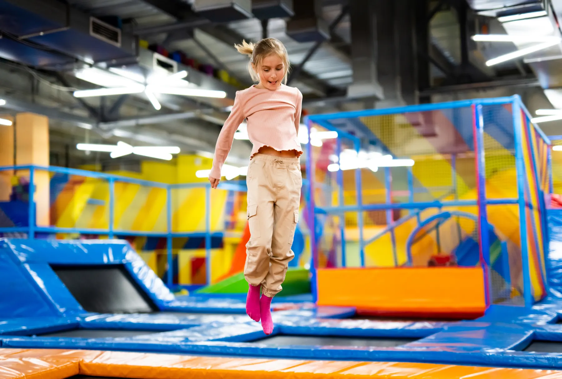 Una niña salta en un parque de trampolines